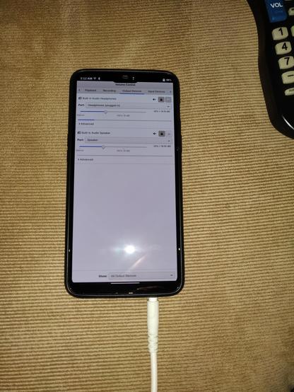 PulseAudio Volume Control on the OnePlus 6 running postmarketOS, showing the active output is Headphones (plugged in) and a cable is shown going into the headphone jack on the bottom of the phone.