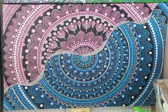 a painting of a mandala design, cropped at the sides, it is blue and pink, one half one color, the other half the other, a wavy line of dots separating the colors