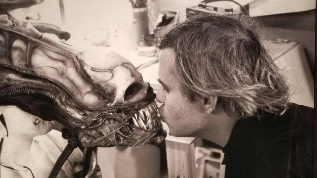 Photo of HR Giger kissing the xenomorph mask