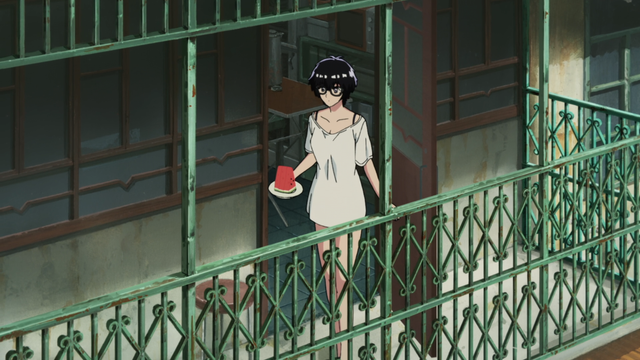 A woman in a large white shirt walking through a door to an apartment balcony holding a plate with a few pieces of watermelon.