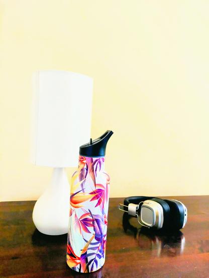 .. three objects on wood desk or wotnot .. a tall white lamp .. headphones of black 'n' silver hue .. & an aluminium water bottle with flower motifs of red, yellow 'n' purple .. [NB the three following snaps are all this image basically, just with different levels of adjustment in the lighting made via the edititing process .. so no need to scroll thru any further ❗️]