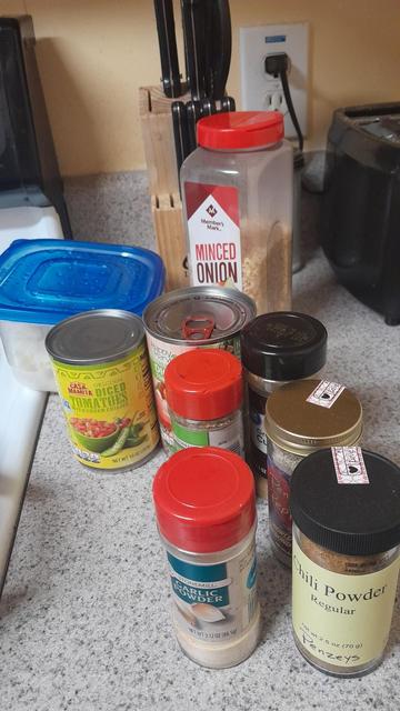 An assortment of spices  including minced onions oregano cumin black pepper chili powder and garlic