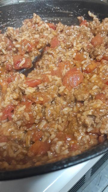 An image in a frying pan of a meat mixture with tomatoes showing