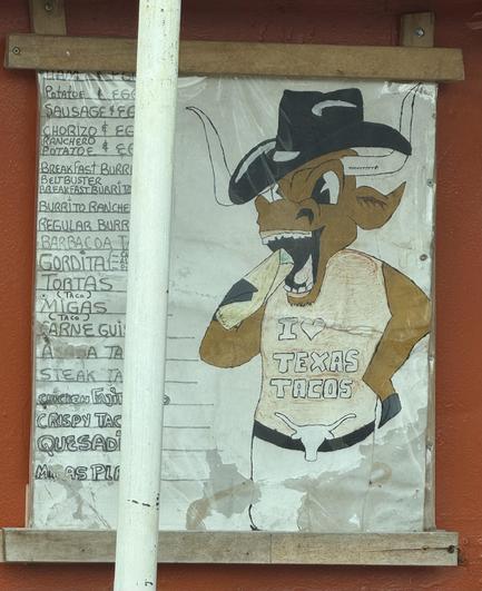 A had drawn Texas longhorn cartoon character with a cowboy hat, eating tacos. The menu appears handwritten beside it