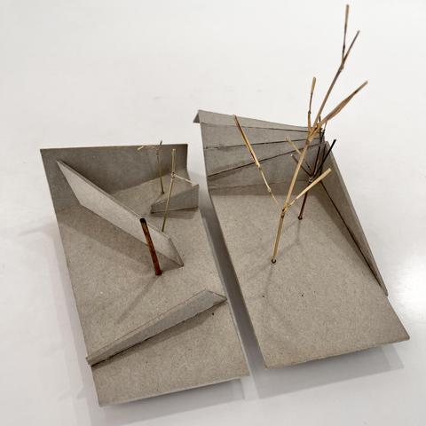 A small  sculpture made of cardboard, two little abstract gardens with shapes and small parts of trees
