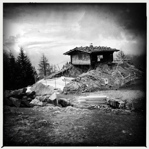 Una malga in legno su di una collina in montagna