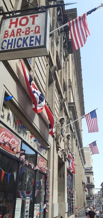 A sign reading "Hot Bar-B-Q Chicken" surrounded by American flags