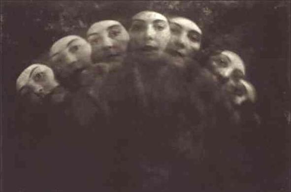 Close-up view of multiple faces, seemingly overlapping, in a dark, grayscale artistic portrait.