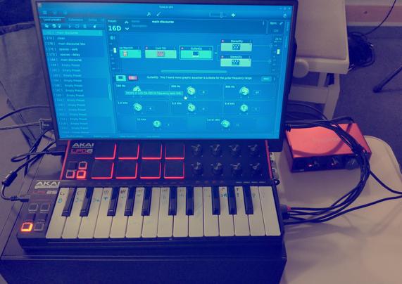 music production setup including sound interface, two midi controllers and a screen showing ToneLibGFX amp simulator.