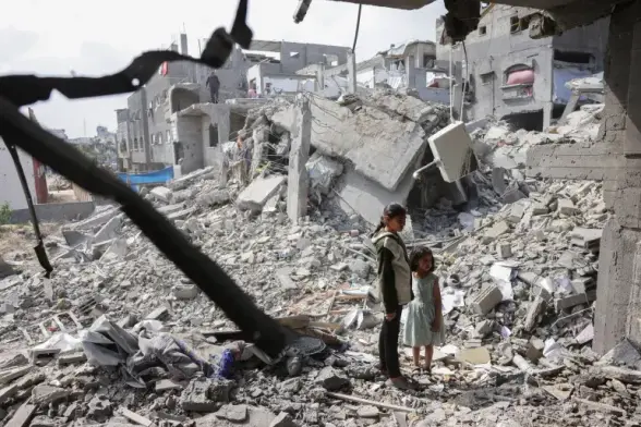 Two children look at the rubble of the Abou Mahadi family house.