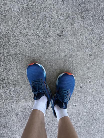A pair of shoes being worn by the viewer seen from the viewer’s perspective 
