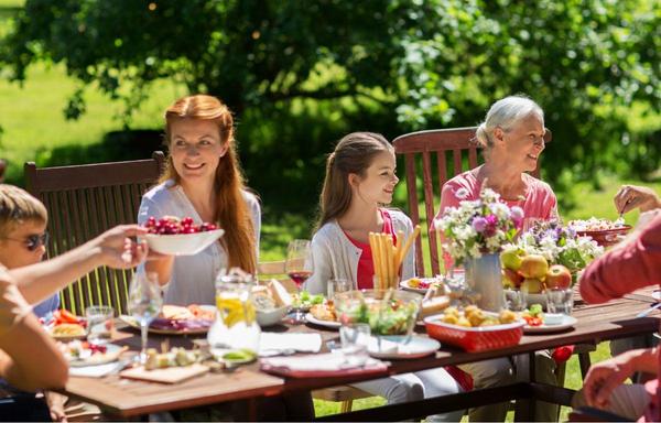 A family enjoying a BBQ outside with summer desserts.
