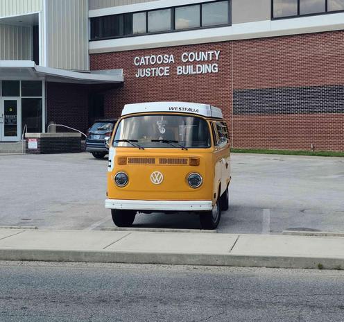 Yellow Volkswagen van parked in front of a brick Catooosa County Justice Building.