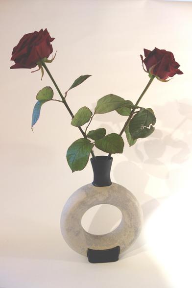 Weiße Vase in Donutform mit zwei Rosen