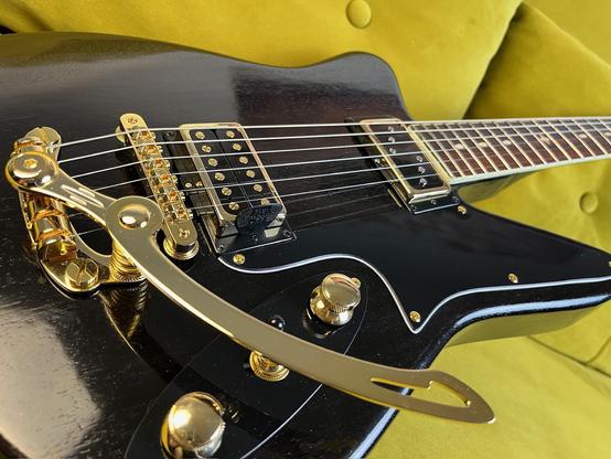 Schwarzer E-Gitarrenkorpus mit goldener Hardware. Detailufnahme.
