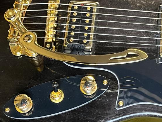 Schwarzer E-Gitarrenkorpus mit goldener Hardware. Detailufnahme.