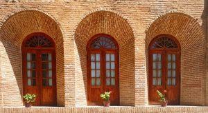 A brick building featuring three elegant arched windows, highlighting its architectural style