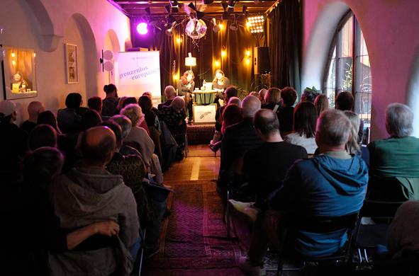 Auf der Bühne Fee Kanzler und Anna Kalmbach unter der Diskokugel im Saal des Ulmer Aegis Cafés. Über fünfzig Leute sitzen im Publikum.