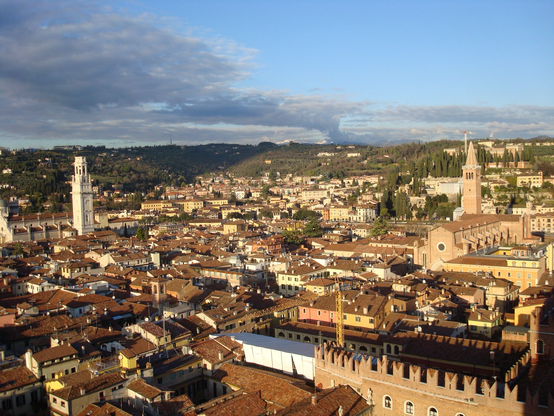 Buildings in the city of Verona spread out until they reach some hills in the distance 