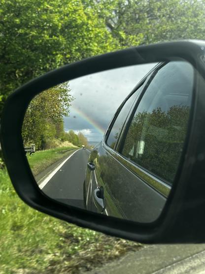 Rainbow seen from a car through the side mirror