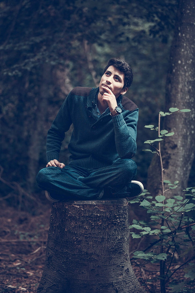 man pondering on a tree