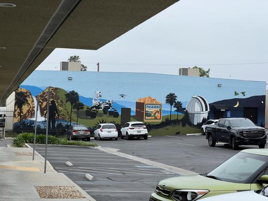 Mural in Pasadena parking lot showing Eaton falls, Mars rover, a box of oranges, Mount Wilson observatory, and the parrots. Always the parrots