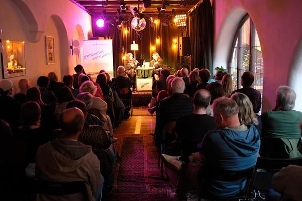 Ein Foto der Gesprächssituation von ganz hinten im Saal. Gut lesbar das Banner des danube book Verlages: Grenzenlos europäisch.