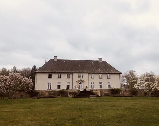 Oremandsgaard Gods seen from the garden, with the beautiful flowering magnolia trees 