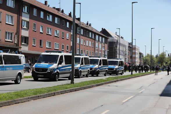 Polizeiwagen und dahinter die Nazidemo. 
