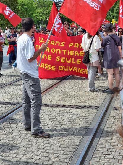 A banner in French reading "No countries, no borders. One working class." (It rhymes in French.)