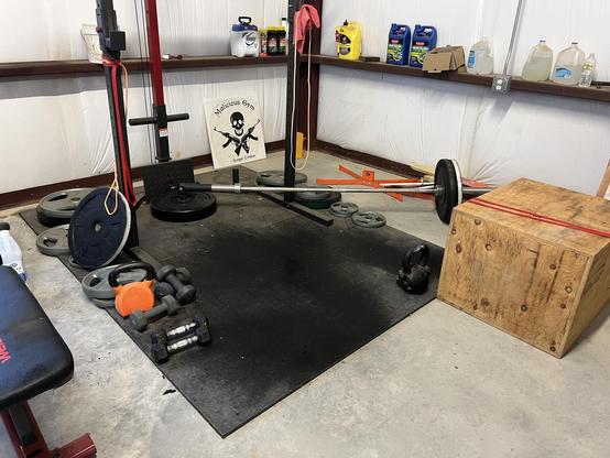 Wooden box, exercise bands, dumbbells, and kettle bells on rubber flooring