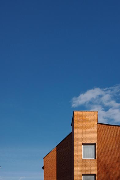 At the bottom, at the edge of the photo is the upper part of a red brick building. The rest of the photo is blue sky. 