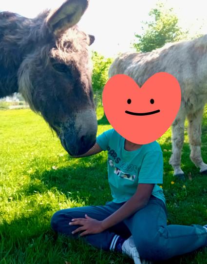 Lui assis dans l'herbe faisant une caresse à Surprise