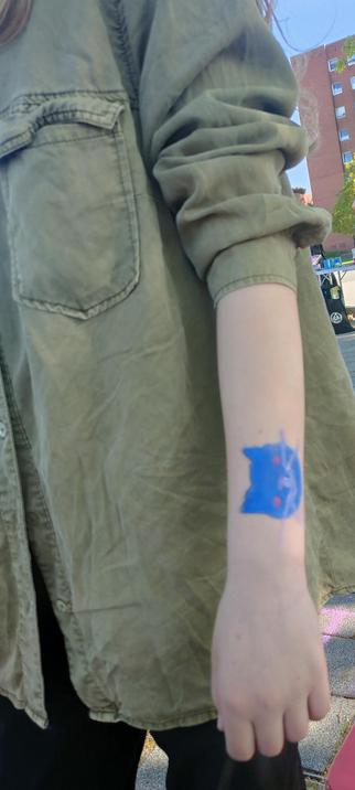 Ein schminkbild einer blauer Katze auf einem Arm