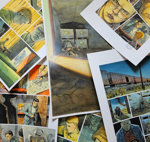 My Out of Alcatraz #2 acrylic gouache original art pages are spread out on a table. Lots of intense faces, a train at night, and a splash page of violence.