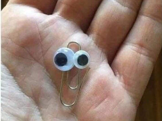 Clippy from old Windows made with a paperclip and 2 googly eyes - in palm of a hand