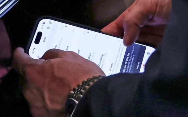 A close-up image of former national security adviser Mike Waltz checking Signal messages on his phone on Wednesday.
Photograph: Evelyn Hockstein/Reuters