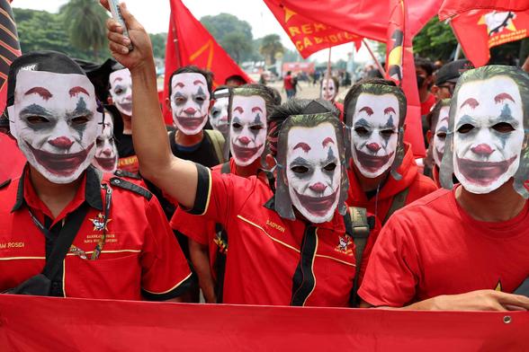 Labourers dressed in red wear Joker masks as they attend a protest during a May Day rally.