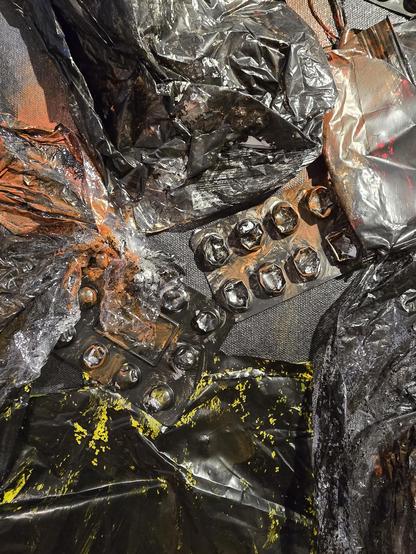 Das Bild zeigt eine Ansammlung von beschädigten und verfärbten Materialien auf einer Oberfläche. Im Zentrum befindet sich ein beschädigtes Tablettenblister, das stark verfärbt und teilweise verbrannt aussieht. Um das Blister sind verschiedene Materialien verteilt, darunter schwarze und silberne Plastikfolien, die ebenfalls verfärbt und beschädigt sind. Einige der Folien haben orangefarbene und gelbe Flecken, was auf eine mögliche Kontamination oder Reaktion mit anderen Substanzen hinweist. Die Oberfläche, auf der alles liegt, scheint eine dunkle, texturierte Material zu sein, möglicherweise ein Teppich oder eine Matte. Die Gesamtkomposition des Bildes vermittelt ein Gefühl von Verwüstung und Verfall.

Bereitgestellt von @altbot, privat und lokal generiert mit Ovis2-8B

