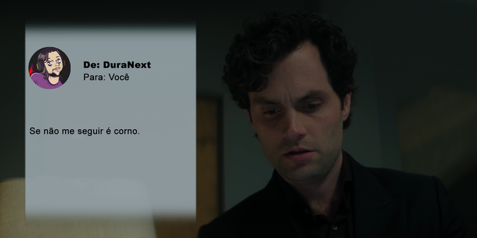 A imagem mostra Joe Goldberg (Penn Badgley), de You, olhando para baixo para seu celular. A tela do celular é visível e mostra uma mensagem de texto de alguém chamado DuraNext, que diz: "Se não me seguir é corno". A expressão de Joe é séria e pensativa, sugerindo uma reação à mensagem. Ele está vestindo uma camisa escura e o fundo é escuro e pouco definido, focando a atenção em Joe e na tela do seu celular. A imagem transmite uma atmosfera de suspense e intriga, característica da série.
