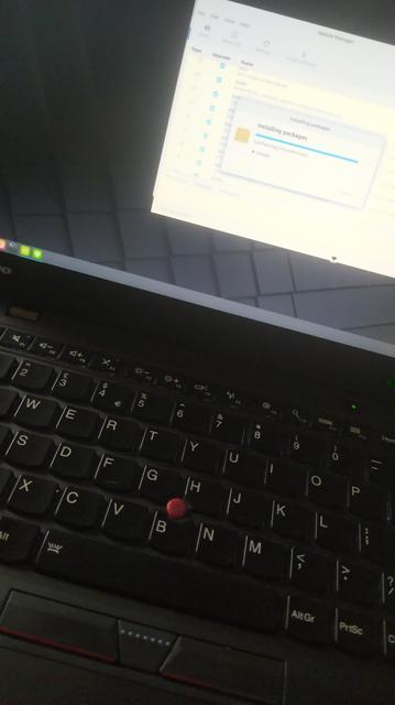 An x1 carbon. Backlit keyboard shining and linux mint Debian edition installing on screen. 