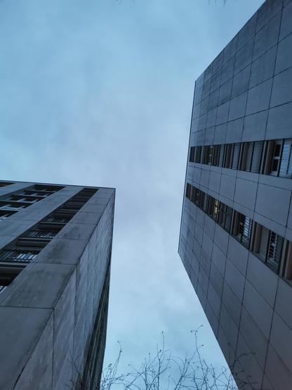 Vue hivernale vers le sommet de deux immeubles voisins, ambiance gris bleu un peu sinistre, ciel et verticalité