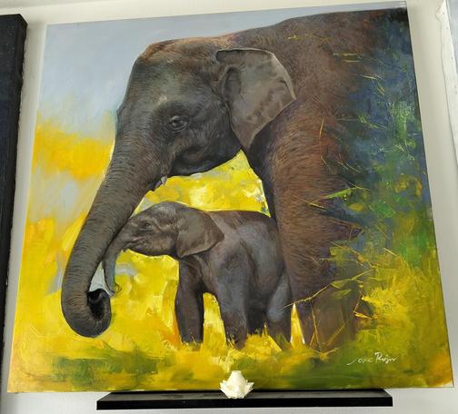 a mother and baby elephant in bright yellow grasses, her baby is rubbing is face against its mother's trunk, they are seen from the side, facing left 