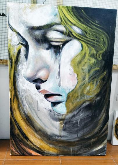 a painting of a close-up of a weeping face, green hair coming down on the right side, a large swoop of gold tones going from the top left to the middle of the right side, a tea rolling down the cheek of the crying face 