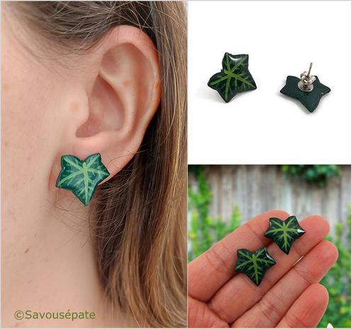 Puces d'oreilles fantaisie éco-responsables en forme de feuilles de lierre vertes.
Les perles sont réalisées en CD recyclé, découpées et peintes à la main, puis recouvertes de résine époxy.
Les tiges sont en acier inoxydable.

L'image est scindée en 3 parties :
- à gauche : on voit la puce d'oreille portée.
- en haut à droite : les puces d'oreilles sont posées sur une surface plane blanche. L'une d'elle est retournée pour que l'on voit la tige à l'arrière.
- en bas à droite : Les puces sont tenues entre les doigts tendus d'une main. En arrière-plan, une clôture en bois gris avec du lierre grimpant dessus. 