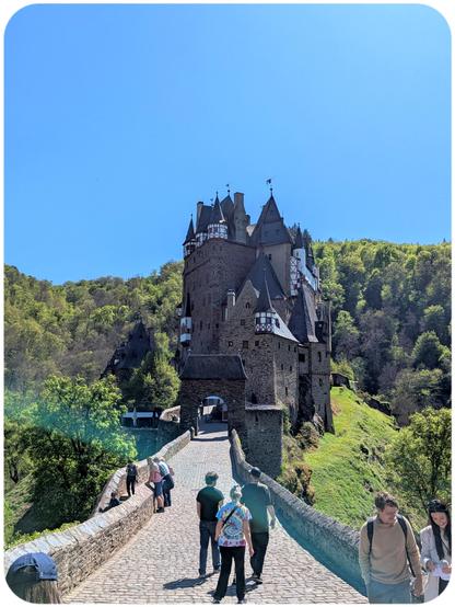 The front view of Burg Eltz in Germany, seen from the footbridge that leads to the castle gates. Both the castle (intact and sprawling with turrets) and the surroundings (it's situated on an elevation in a valley) are breathtaking.