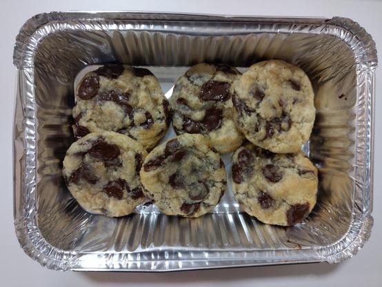 6 chocolate chip cookies in a tin container.