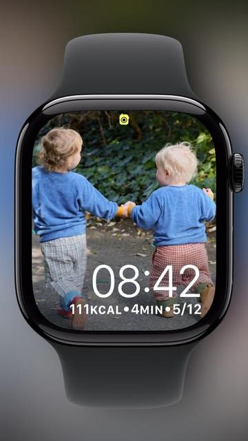 Image of an Apple Watch screen displaying two young children holding hands, walking away. The kids are wearing blue sweaters and have light-colored hair. Time shows 08:42, with activity stats of 111 kcal burned, 4 minutes of exercise