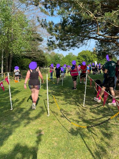 Two parallel funnels (three plastic chains on stakes making two lanes) at parkrun, with runners in both