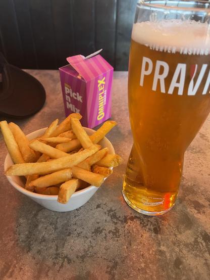 A pint of Pravha lager, a bowl of fries, and a cinema pick n mix sweet box. 